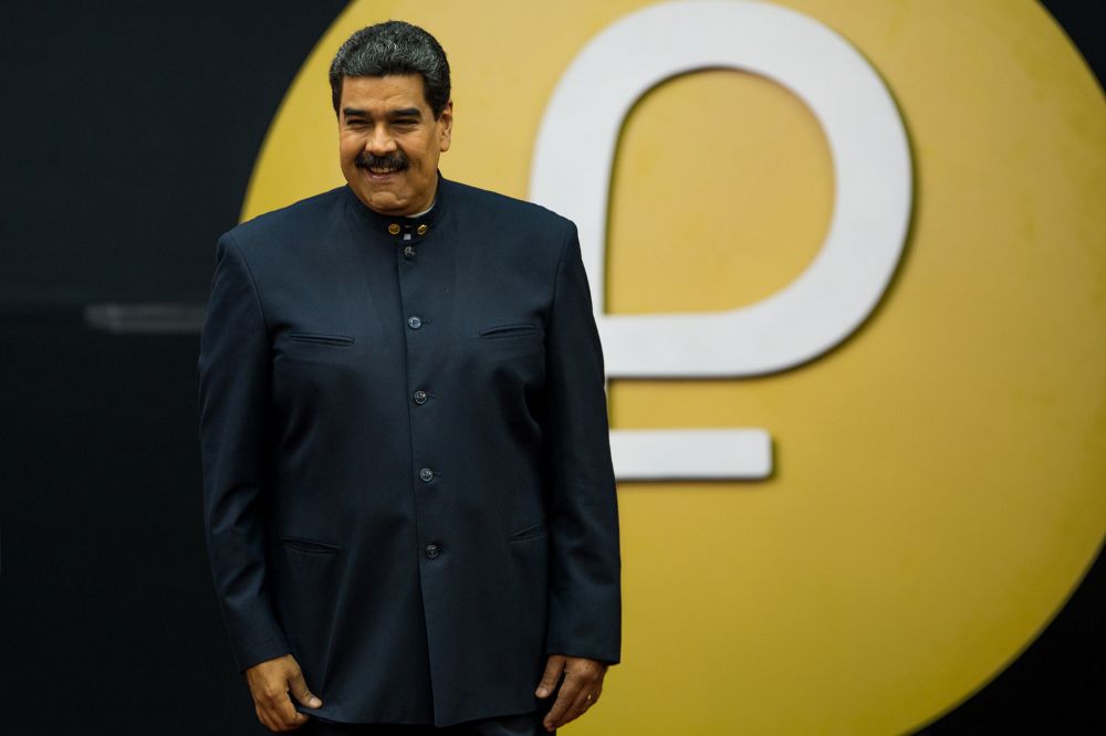 El presidente venezolano, Nicolás Maduro, dirige una rueda de prensa junto a un logo de la criptomoneda Petro.
