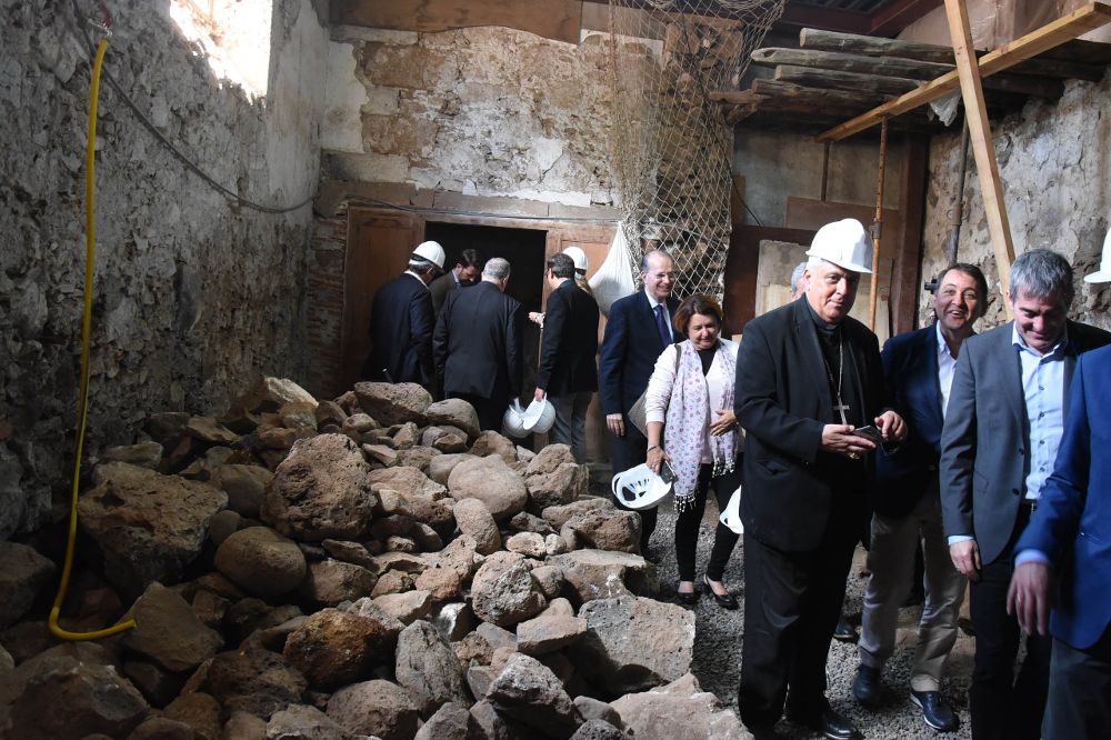 El obispo (con casco) y los políticos recorren las estancias deterioradas del templo.