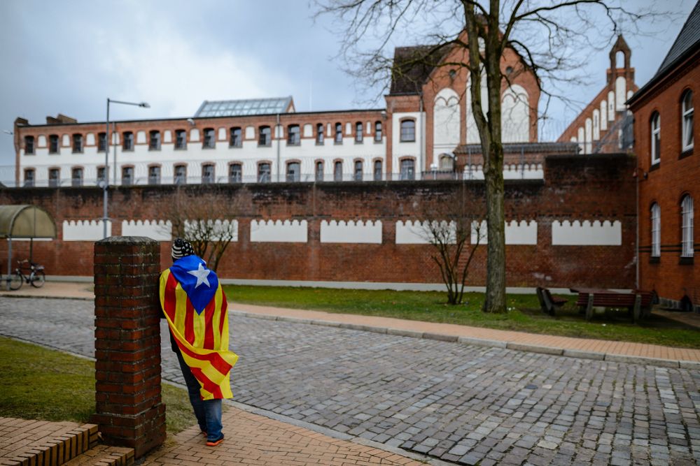 Un hombre con una bandera estelada permanece ante la cárcel de Neumünster, donde está recluido el expresidente catalán Carles Puigdemont, en Alemania.