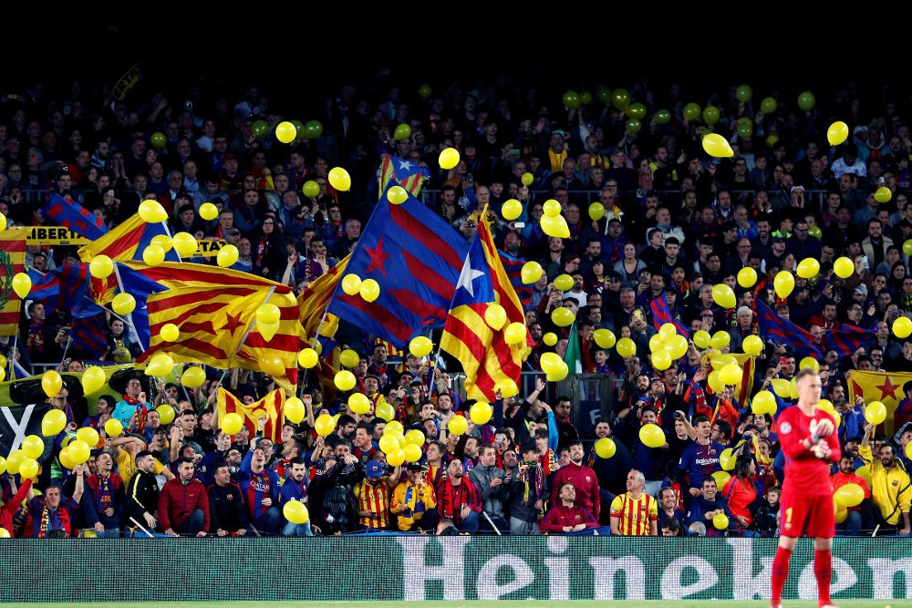 Aficionados en la grada sueltan globos amarillos en defensa de los independentistas encarcelados durante el partido.