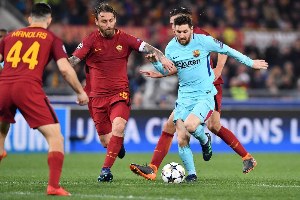 El jugador de la Roma Daniele De Rossi (i) marca a Lionel Messi (d), del Barcelona, hoy, martes 10 de abril de 2018, durante un partido entre la Roma y el Barcelona por los cuartos de final de la Liga de Campeones de la UEFA, en el estadio Olímpico de Roma (Italia).