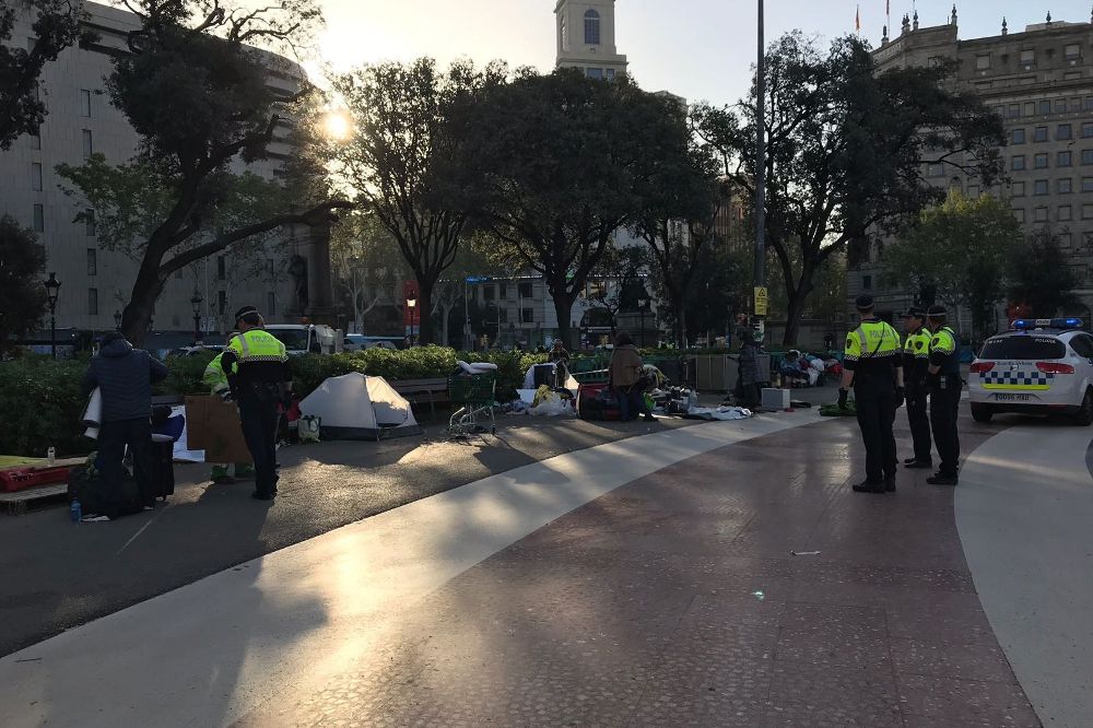 Agentes de la Guardia Urbana durante el desalojo del campamento de personas sin techo de la plaza Catalunya.