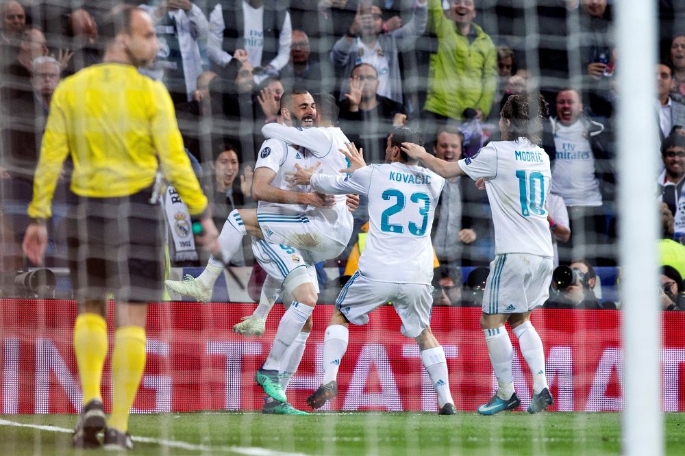 El delantero francés del Real Madrid Karim Benzema (i) celebra con sus compañeros su segundo gol.