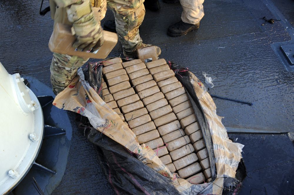 Fotografía cedida por las Fuerzas marítimas del Pacífico de la Armada Real Canadiense donde aparece un miembro de la Guardia Costera de los Estados Unidos sacando paquetes de cocaína de un bulto durante la Operación CARIBBE, el 5 de abril.