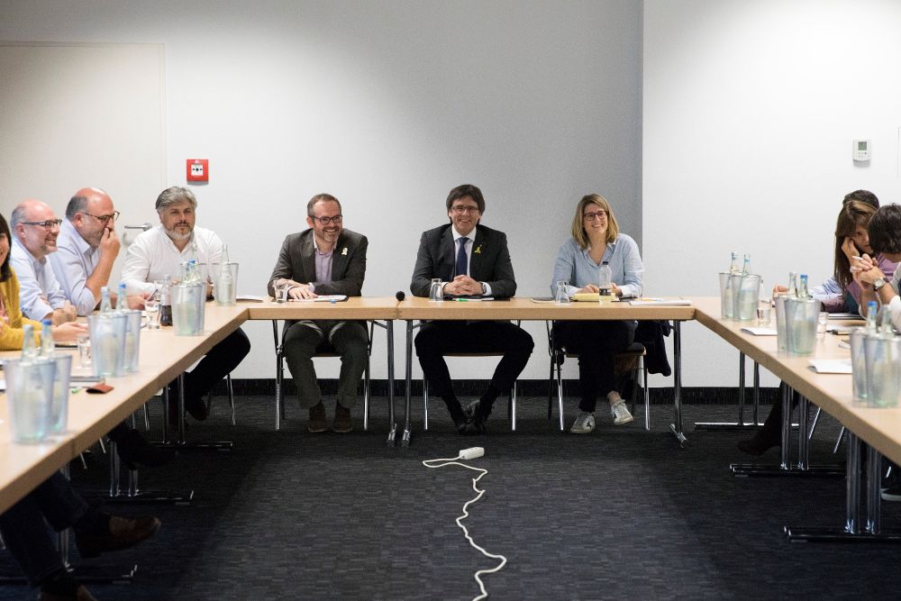 Puigdemont (fondo-c), junto a la portavoz de JxCat, Elsa Altadi (fondo-d), y el vicepresidente primero de la Mesa del Parlament, Josep Costa (fondo-i), durante una reunión en Berlín.