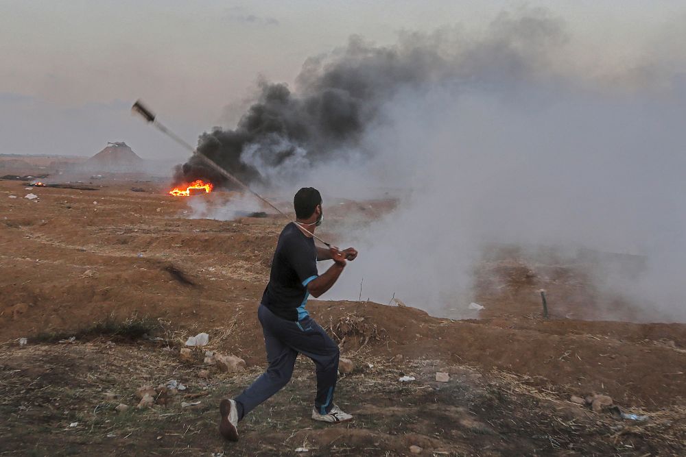 Un manifestante palestino arroja piedras con una honda cerca de la frontera este de la ciudad de Gaza