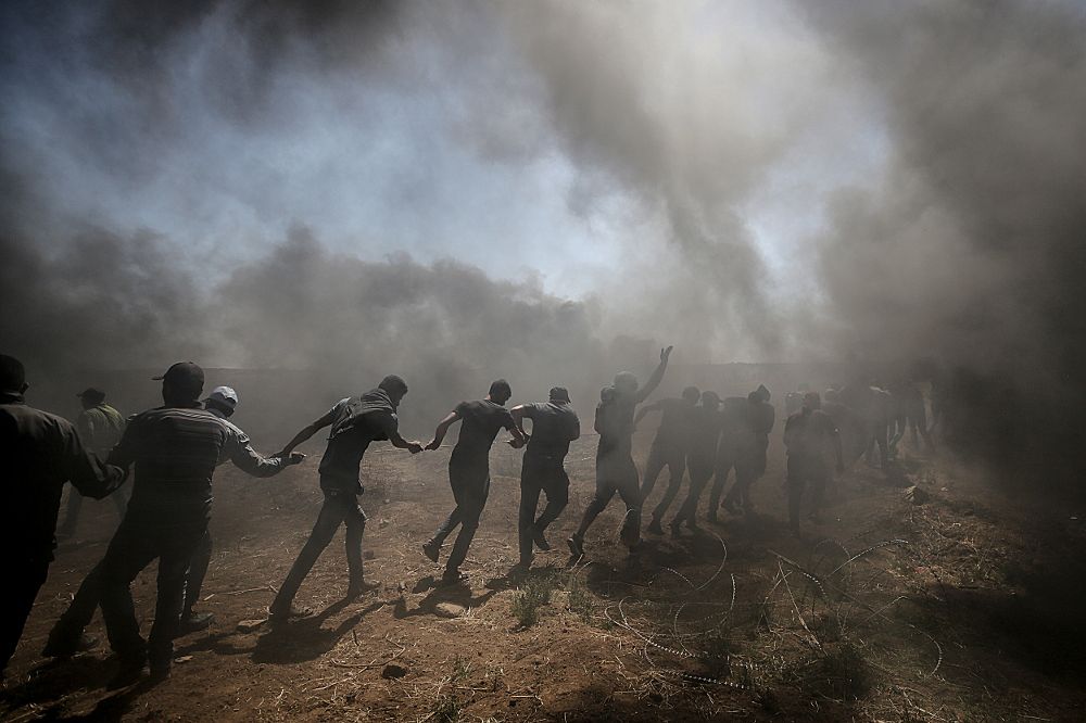 Manifestantes palestinos tratan de tirar el alambre instalado por el ejército israelí a lo largo de la frontera.