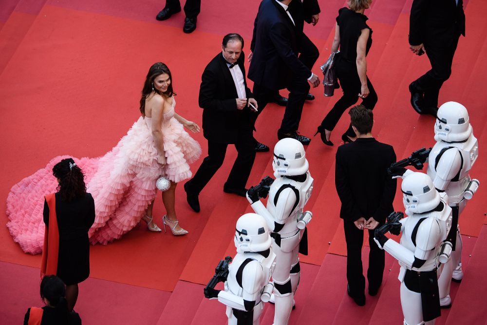 Visitantes pasan junto Stormtroopers a su llegada a la alfombra roja para la proyección de "Solo: A Star Wars Story" durante la edición 71 del Festival de Cine de Cannes.