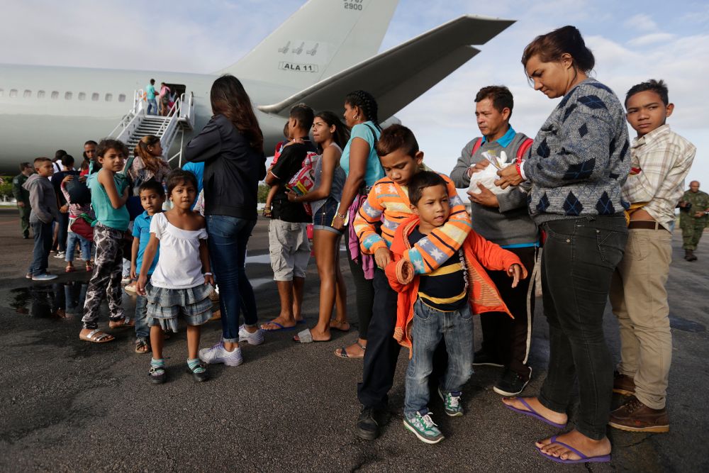 Decenas de emigrantes venezolanos esperan para subir a un avión en el aeropuerto de Boa Vista (Brasil), lugar de acogida, para trasladarlos a otros puntos del país como Sao Paulo y Manaus.