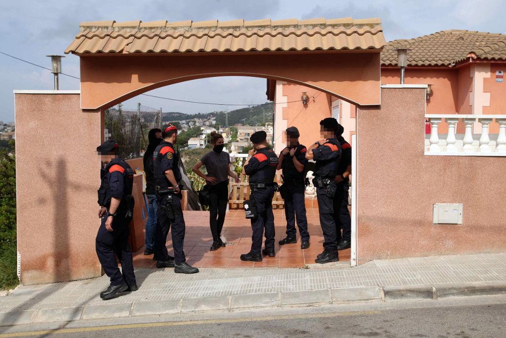 Los Mossos d'Esquadra custodian la entrada de una vivienda en la calla María de Montserrat de Segur de Calafell (Tarragona), en el marco de una ampla operación que están desarrollando esta mañana contra el tráfico de marihuana.