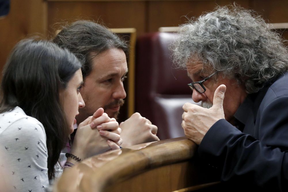 El diputado de ERC Joan Tardá (d) conversa con el líder de Podemos, Pablo Iglesias y la portavoz, Irene Montero, durante el pleno del Congreso de los Diputados, esta tarde en Madrid.