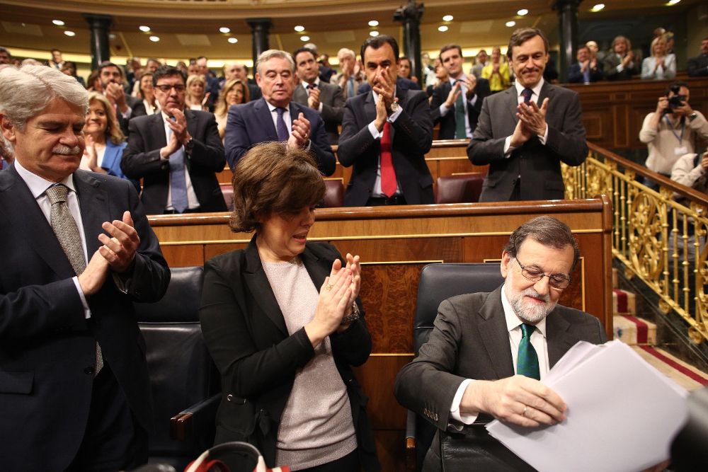 Alfonso Dastis y Soraya Saenz de Santamaría aplauden a Rajoy durante la moción de censura, esta mañana.