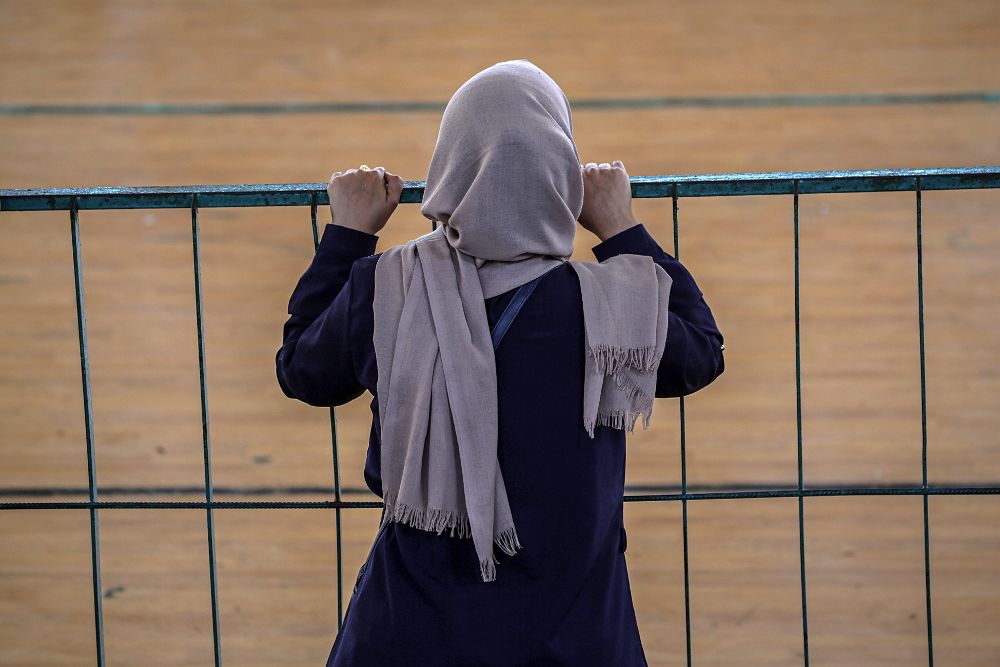 Una mujer palestina espera para cruzar la frontera de Rafah entre Egipto y la Franja de Gaza.