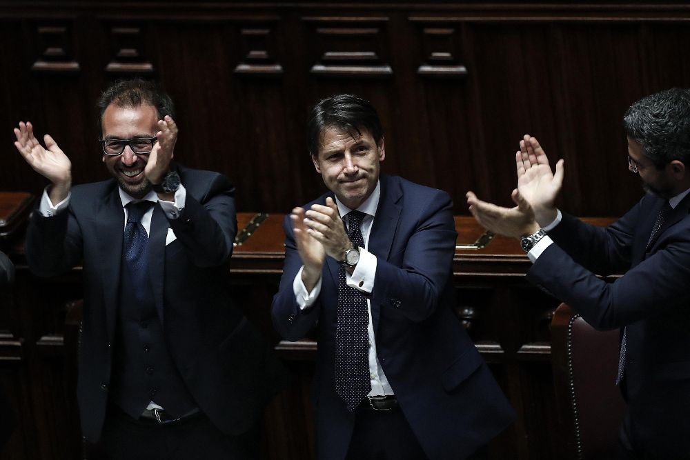 El nuevo primer ministro de Italia, Giuseppe Conte (c), y los ministros Riccardo Fraccaro (d) y Alfonso Bonafede (i) celebran los resultados tras la votación para el nuevo gobierno en el Congreso de los Diputados en Roma, Italia.