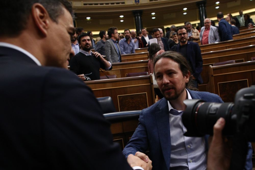 Pedro Sánchez saluda a Pablo Iglesias tras ser elegido presidente del Gobierno.