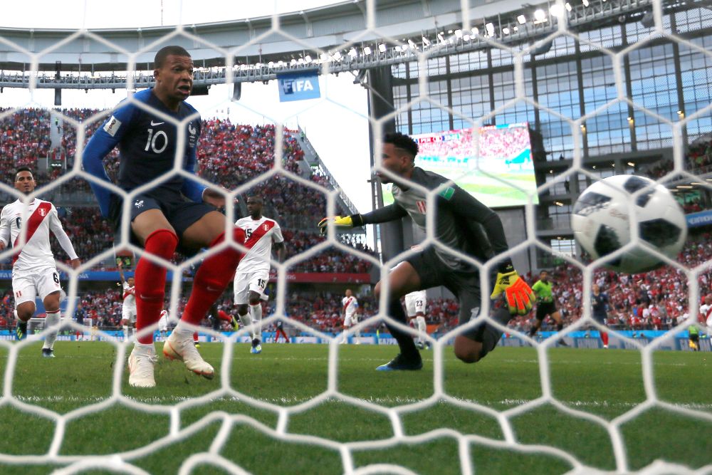 El delantero francés Kylian Mbappé (d) marca el 1-0 durante el partido Francia-Perú.