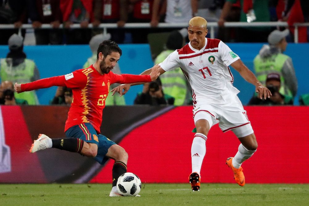 El centrocampista español Isco (i) y el defensa marroquí Nabil Dirar.