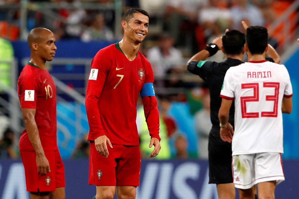 El delantero portugués Cristiano Ronaldo (2-d) reacciona después de que el árbitro paraguayo Enrique Cáceres consulte el VAR durante el partido Irán-Portugal.