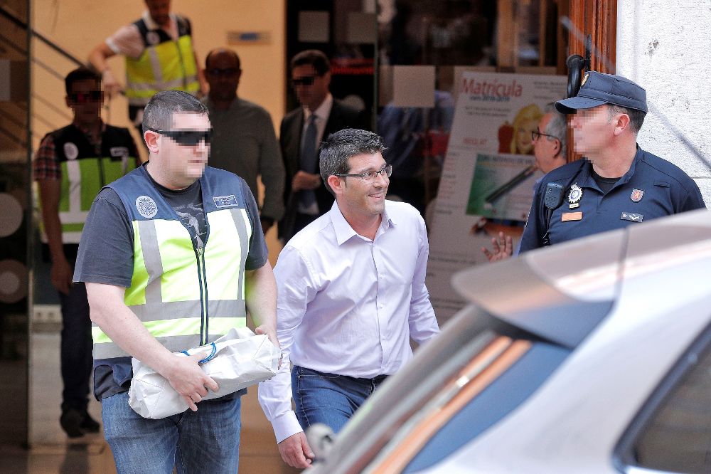 Jorge Rodríguez (c), y su jefe de gabinete, Ricard Gallego (fondo), salen del ayuntamiento custodiados por agentes de la UDEF tras más de siete horas de registro.