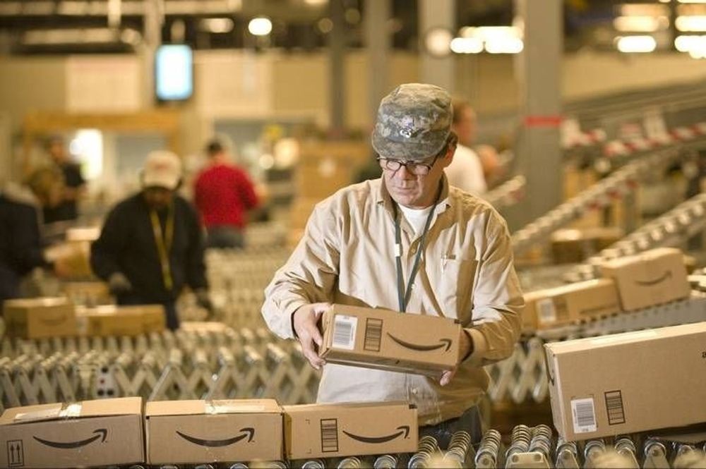 Un trabajador de Amazon empaqueta regalos promocionales.