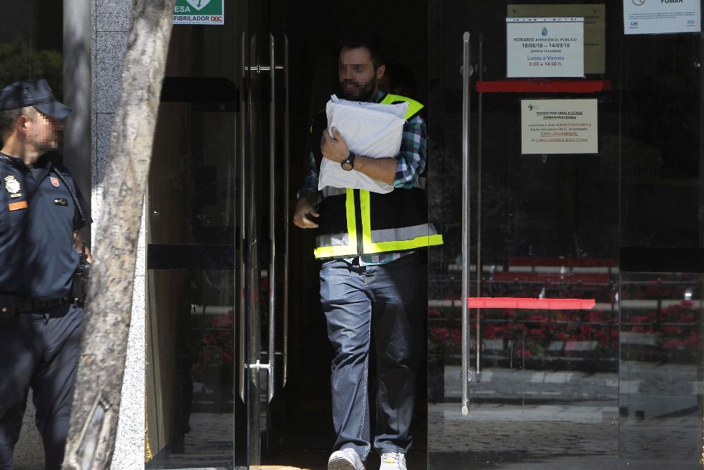 Agentes policiales a su salida hoy del Ayuntamiento madrileño de Torrelodones, uno de los registrados en la operación.