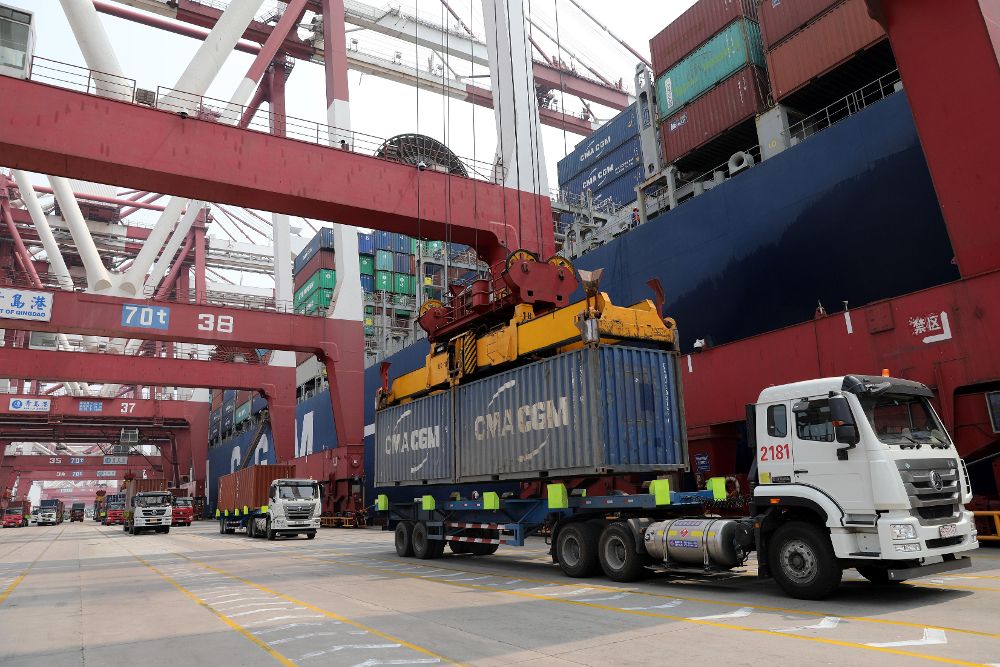 Foto de archivo de un camión mientras descarga un contenedor en el puerto de Qingdao (China).