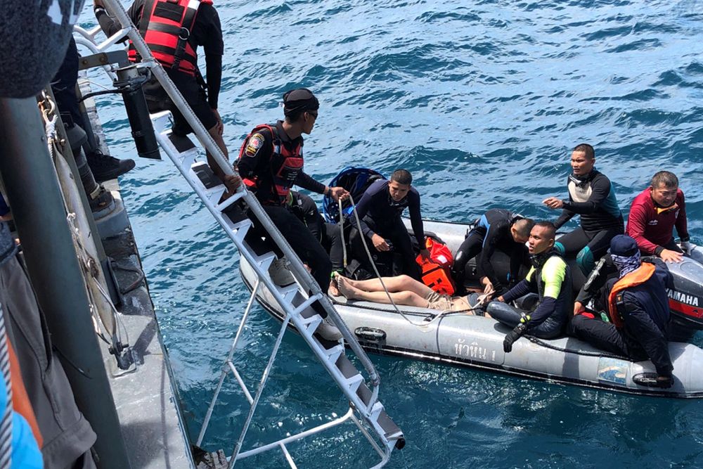 Efectivos de la Marina, policía y miembros de los servicios de rescate tailandeses rescatan el cadáver de un turista de un naufragio frente a la costa de Phuket.