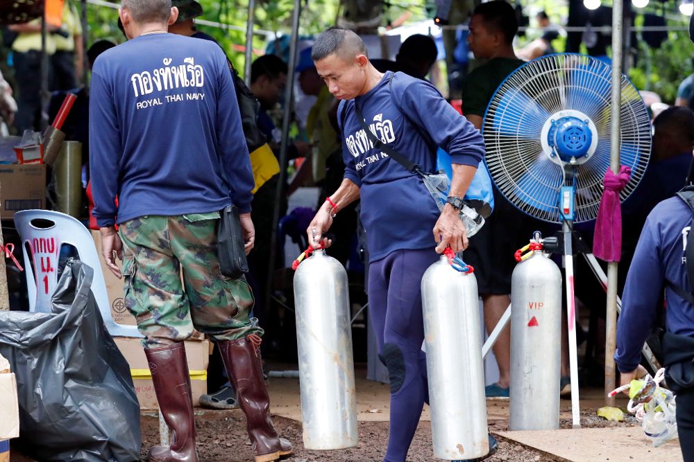 Personal de la Marina tailandesa carga tanques de oxígeno durante las operaciones de rescate en la cueva Tham Luang.