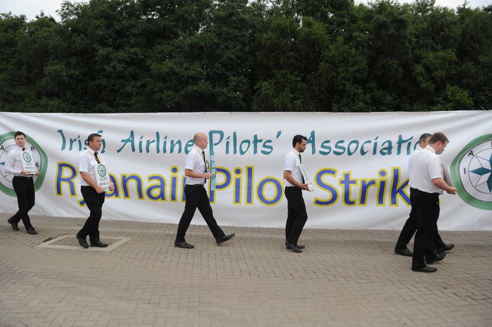 Pilotos irlandeses de Ryanair sujetan pancartas durante una protesta en el aeropuerto de Dublín, Irlanda, hoy, 12 de julio.