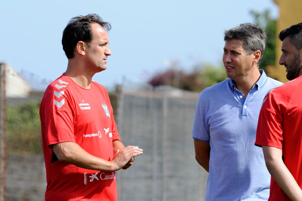 El entrenador (i) conversa en el entrenamiento con Alfonso Serrano (c), director deportivo.