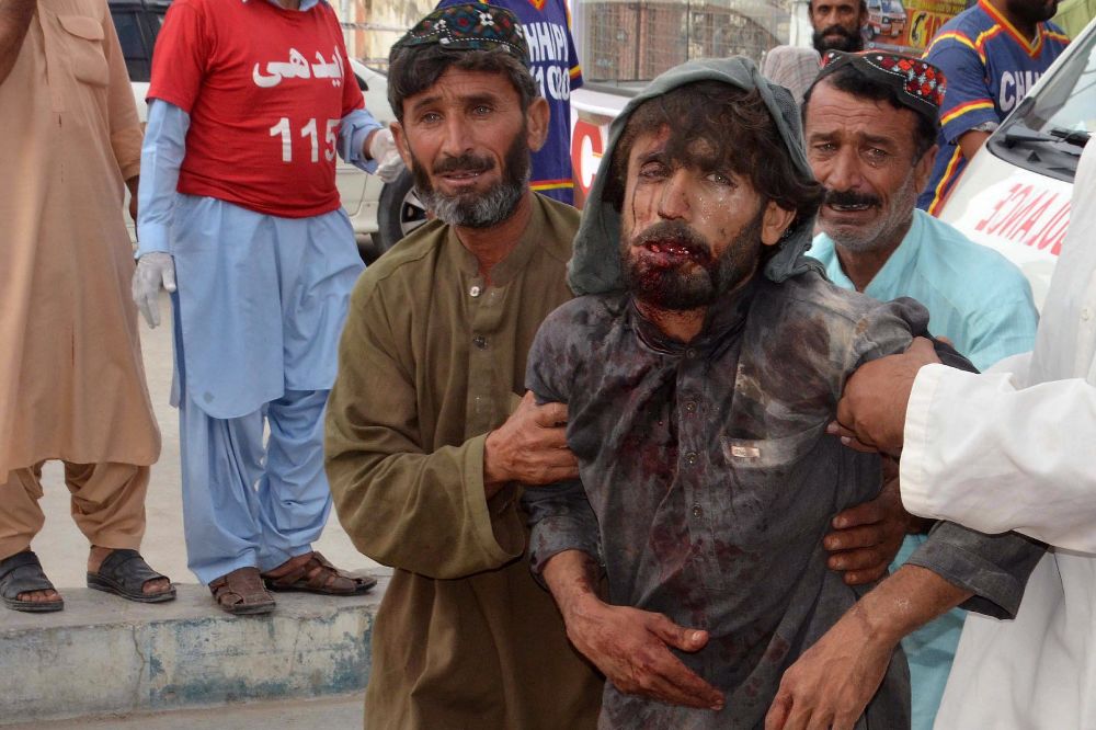 Varias hombres desplazan a una víctima del atentado bomba contra un acto electoral del Partido Nacionalista Awami (ANP) al hospital, en Quetta (Pakistán).
