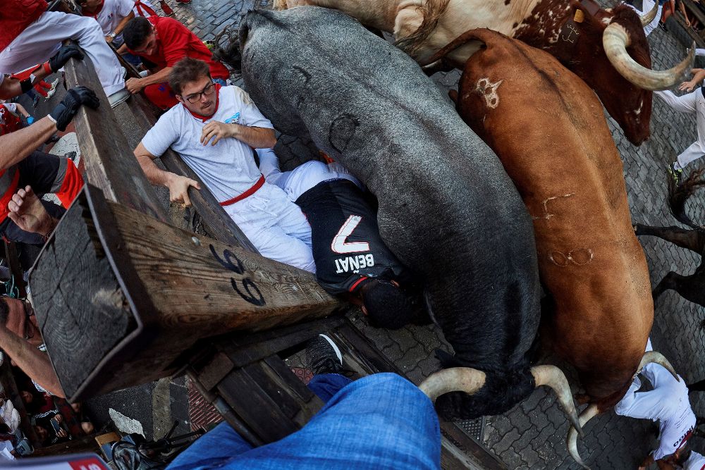 Los toros de la ganadería sevillana de Miura aplastan a varios mozos contra la valla del tramo de Telefónica durante el octavo y último encierro de los Sanfermines 2018.