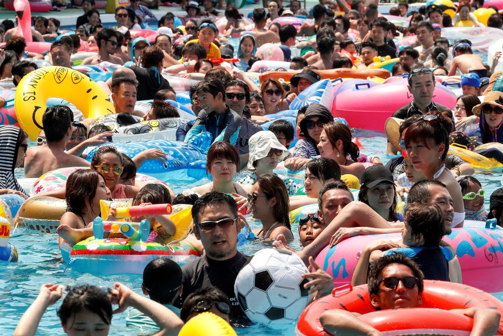 Bañistas japoneses se empujan unos a otros en una piscina del parque de atracciones de Toshimaen, en Tokio, Japón.