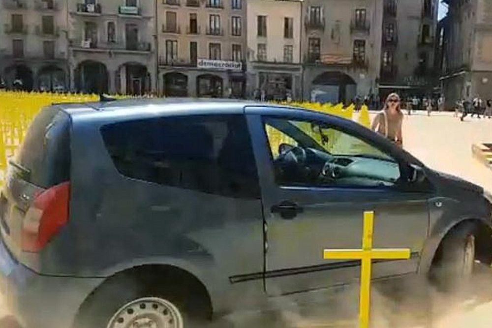 Fotografía tomada de un video del twitter del Ayuntamiento de Vic, del coche que irrumpió en la plaza Major, llevándose por delante varias cruces de los independentistas.