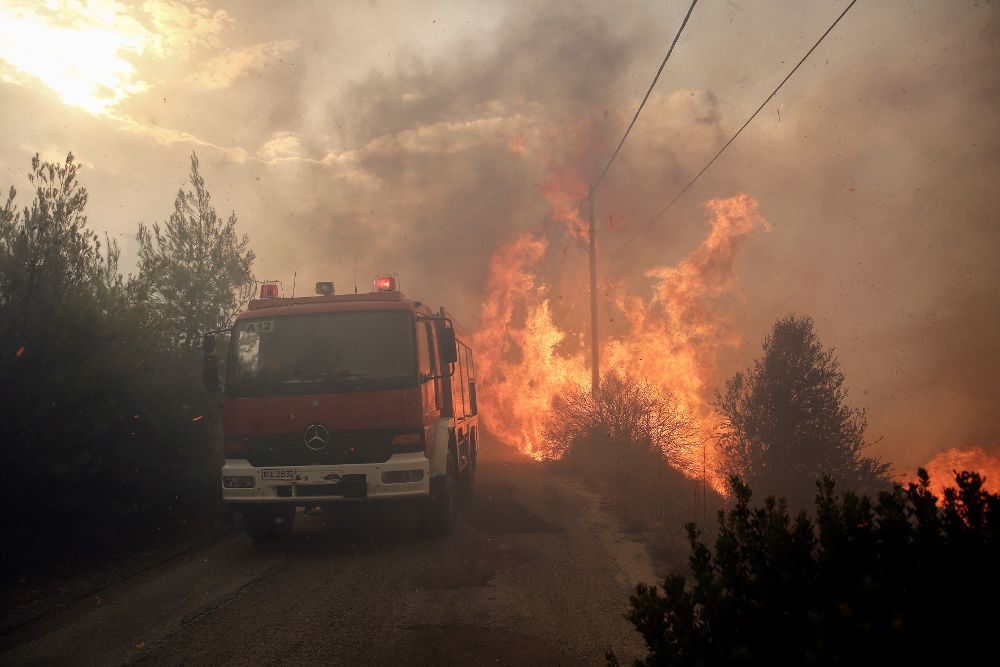 omberos tratan de extinguir un incendio en Penteli, al norte de Atenas.