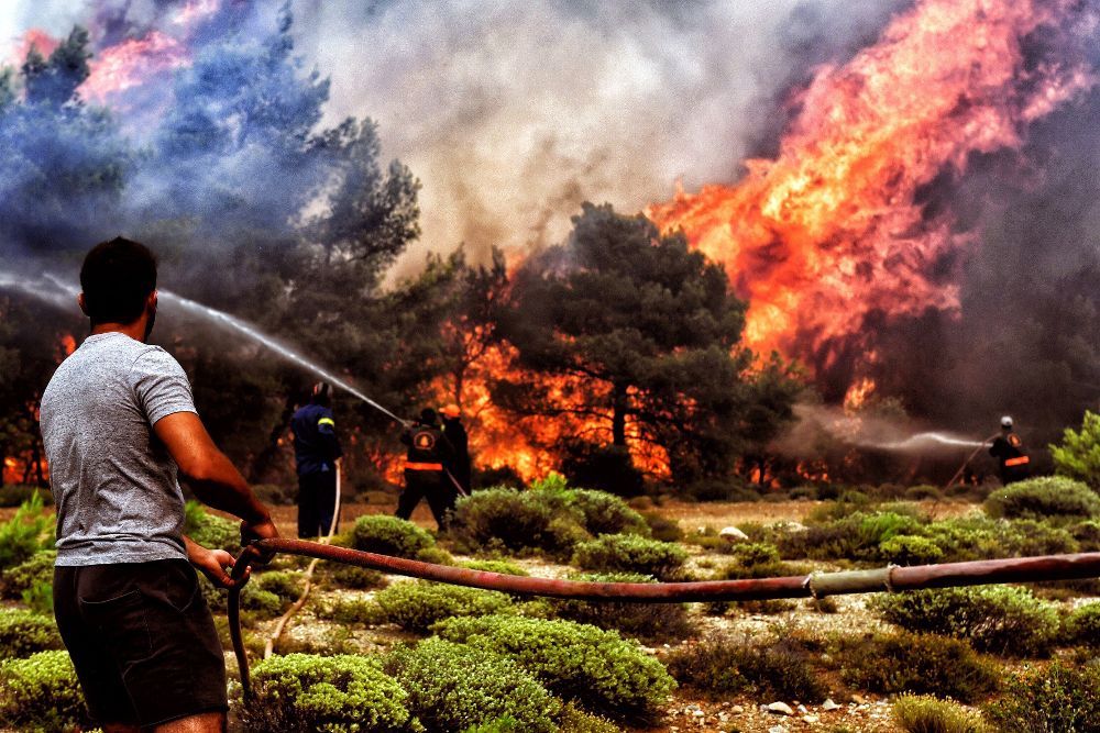 Varios bomberos y voluntarios luchan contra las llamas en Verori, cerca de la ciudad de Loutraki.