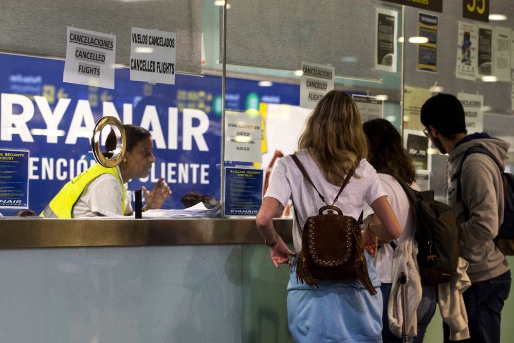 Trabajadoras del servicio de atención al cliente de Ryanair del aeropuerto de El Prat, en Barcelona, informan a los usuarios de la huelga.