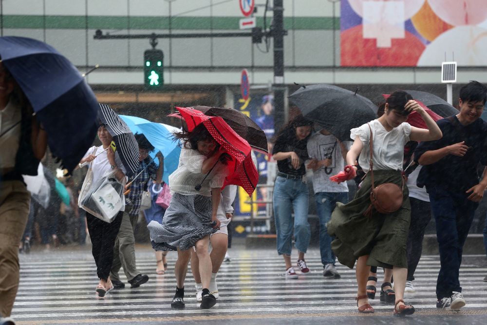 Una calle de Tokio el pasado 28 de julio, con viandantes que se protegen del fuerte viento y la lluvia.