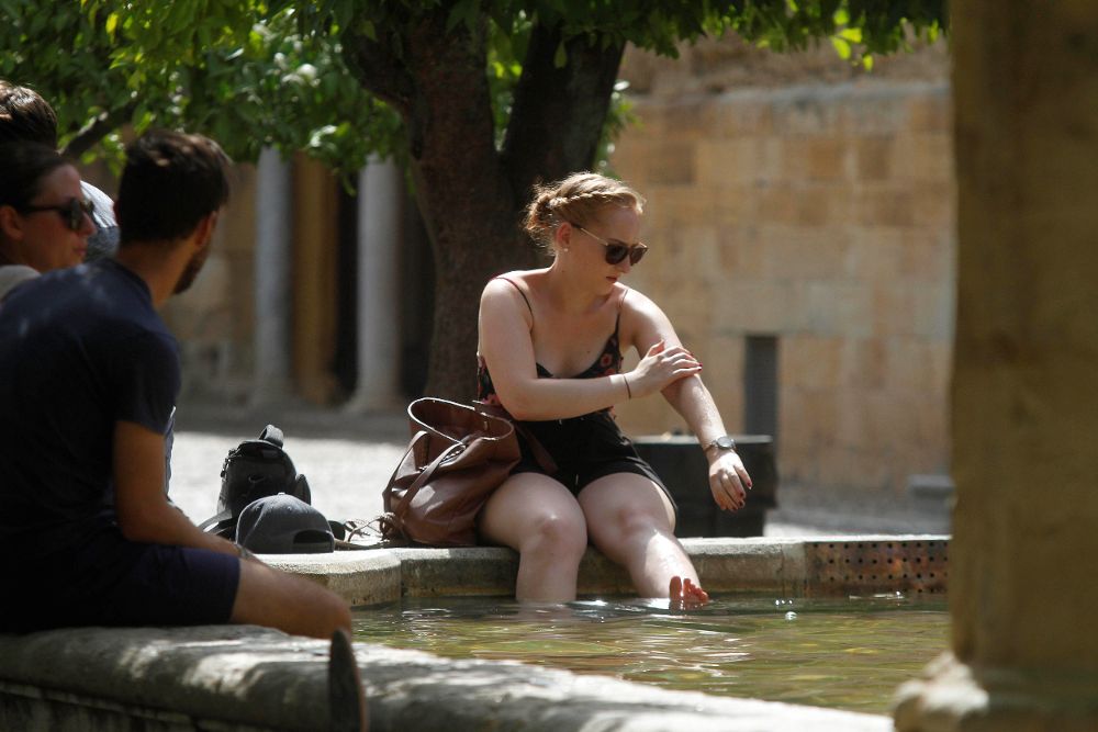 Turistas se refrescan en unas de las fuentes del Patio de los Naranjos de la Mezquita-Catedral de Córdoba.
