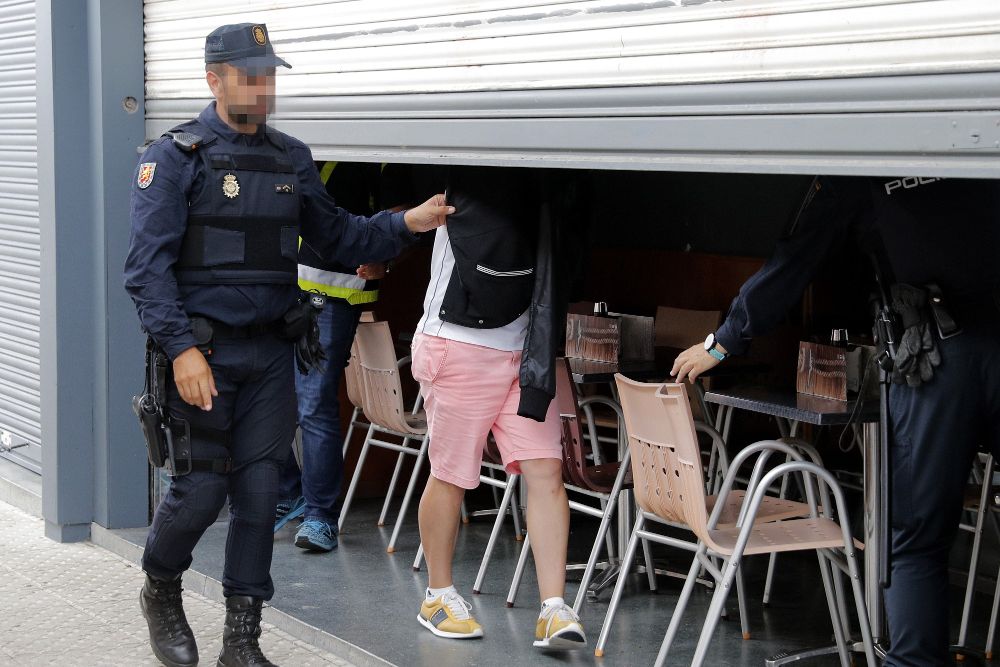 Agentes de la Policía Nacional acompañados en el registro por un detenido, inspeccionan un local de hostelería de Boiro, en la operación antidroga en la que también han sido detenidos Manuel Charlín Gama y uno de sus hijos, Melchor.
