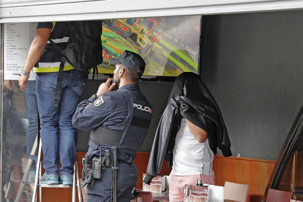 Agentes de la Policía Nacional acompañados en el registro por un detenido, inspeccionan un local de hostelería de Boiro, en la operación antidroga en la que también han sido detenidos Manuel Charlín Gama y Melchor Charlín Pomares. 