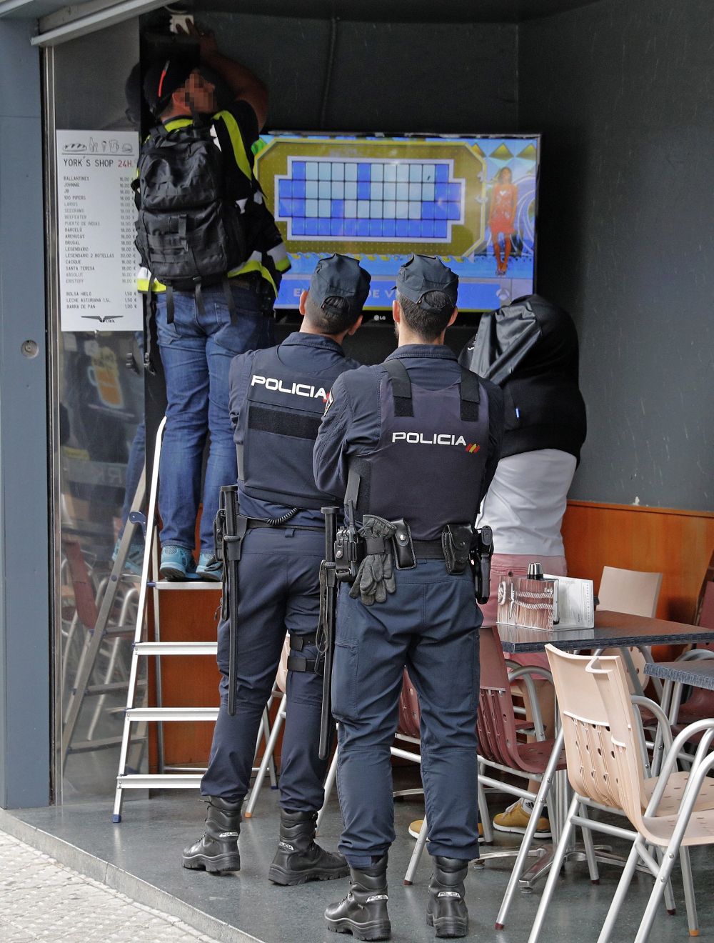 Agentes de la Policía Nacional, acompañados en el registro por un detenido, inspeccionan un local de hostelería de Boiro, en la operación antidroga en la que fueron detenidos los Charlines.