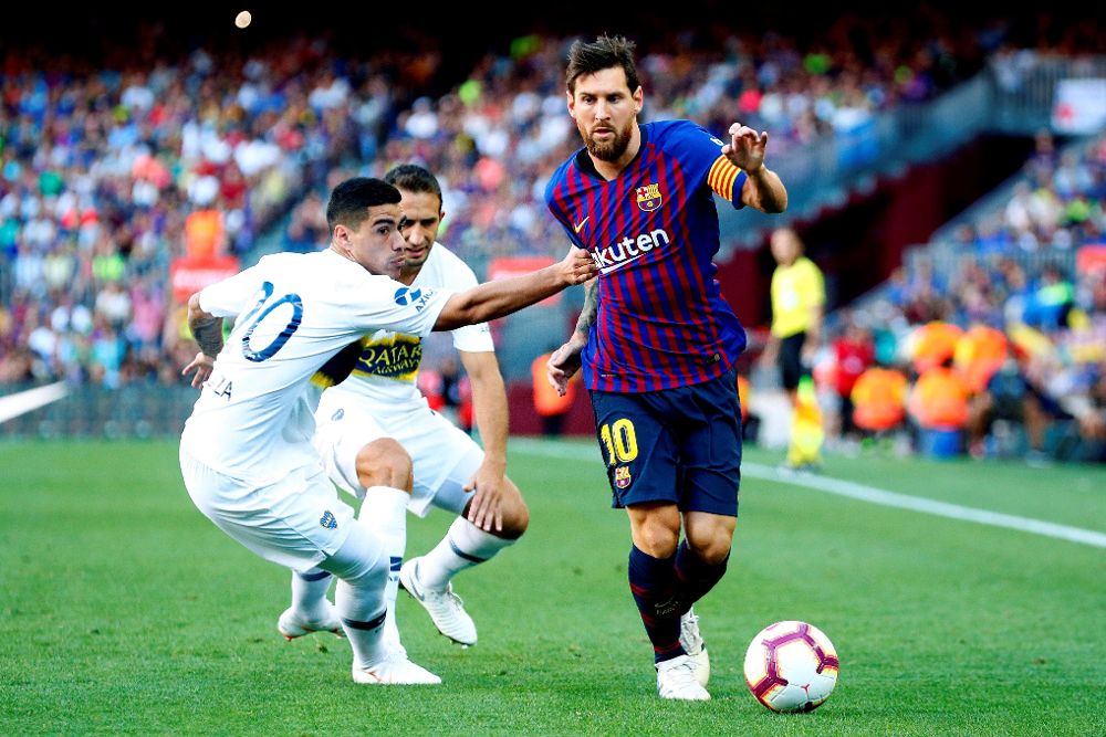 Messi (d) pelea un balón con el defensa de Boca Juniors Lucas Olaza durante el trofeo Joan Gamper, esta tarde en el Nou Camp. 