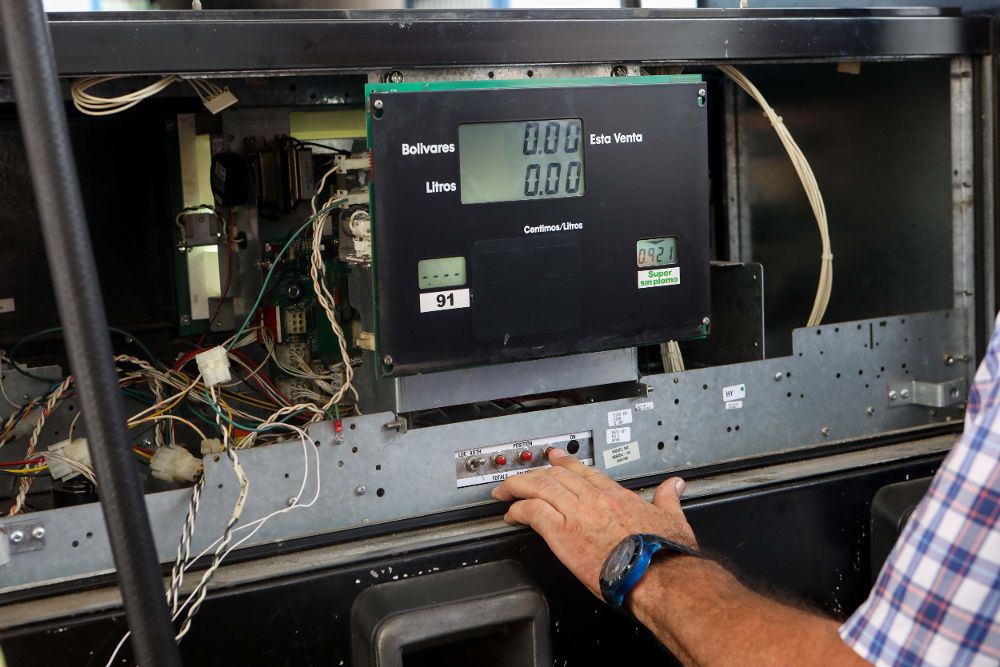 Técnicos hacen mantenimiento a dispensadoras de gasolina.