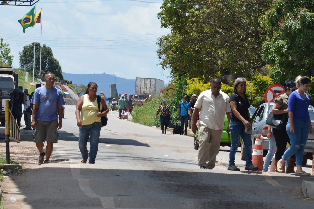 Venezolanos cruzan la frontera entre Brasil y Venezuela.