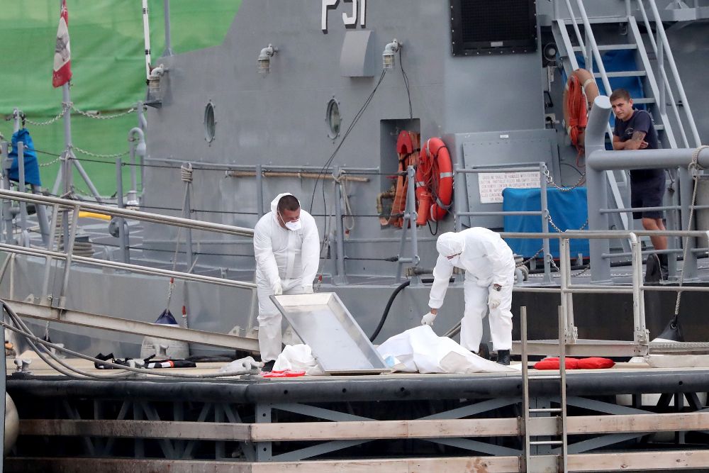 El cuerpo sin vida de un inmigrantes a bordo del barco de las Fuerzas Armadas de Malta es desembarcado en la base naval de Haywharf, Floriana.
