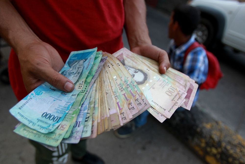 Un venezolano ofrece billetes de su país fuera de la terminal de transportes en Cali (Colombia.