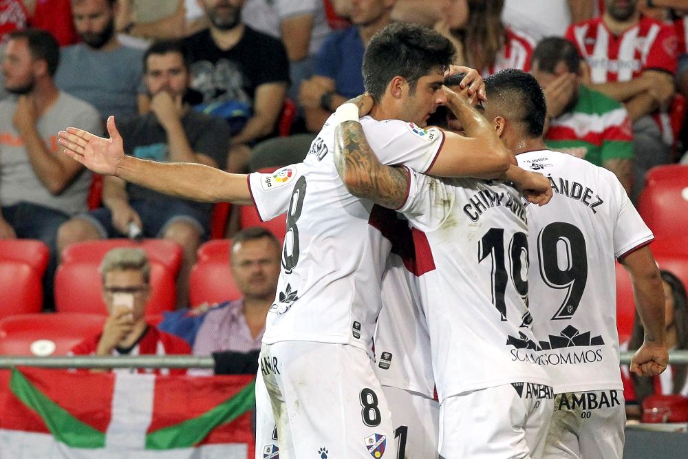 Los jugadores del Huesca celebran el segundo gol del equipo oscense durante el encuentro correspondiente a la segunda jornada de primera división disputado esta noche frente al Athletic en el estadio de San Mamés, en Bilbao.