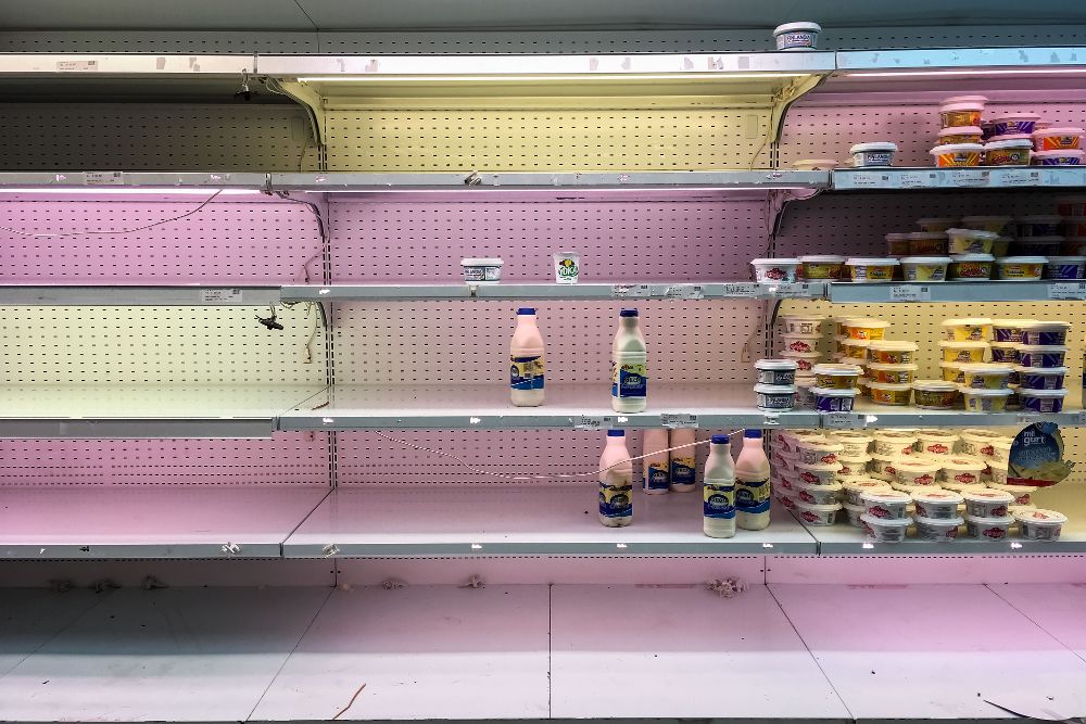 Fotografía de los estantes parcialmente vacíos de un supermercado.