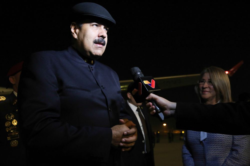 Fotografía cedida por la oficina de prensa de Miraflores, del presidente venezolano, Nicolás Maduro (i), hablando con la prensa a su llegada a Pekín (China).
